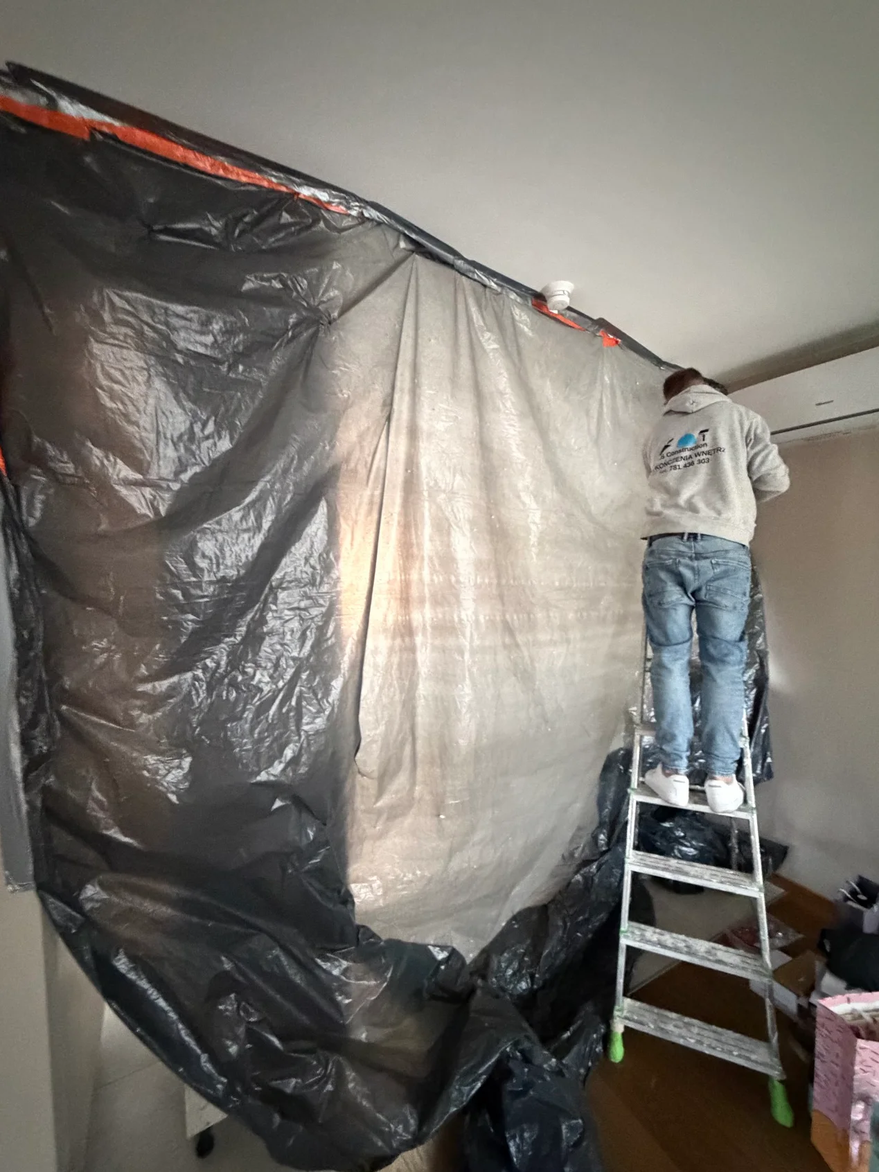 Technik zabezpieczający pomieszczenie folią przed ozonowaniem