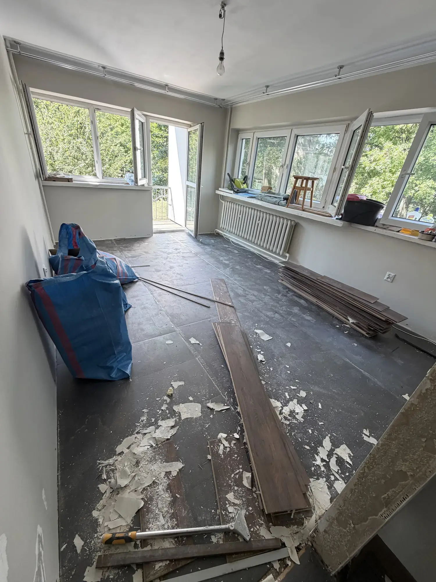 Pokój po zerwaniu podłogi, z workami na usunięte materiały
