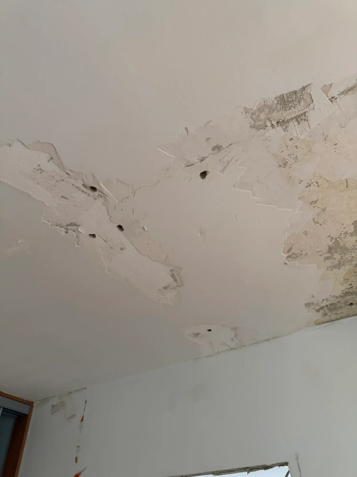 Odspojone fragmenty tynku na suficie zalanego mieszkania